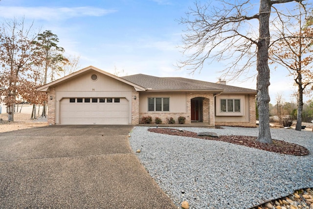 ranch-style house featuring aphalt driveway, brick siding, a chimney, a shingled roof, and an attached garage