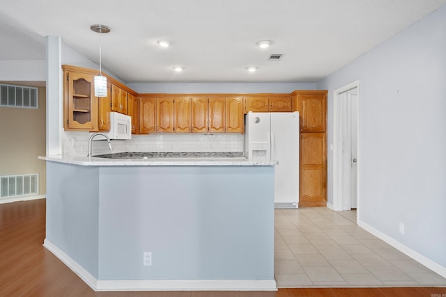 kitchen featuring white appliances, visible vents, and a peninsula