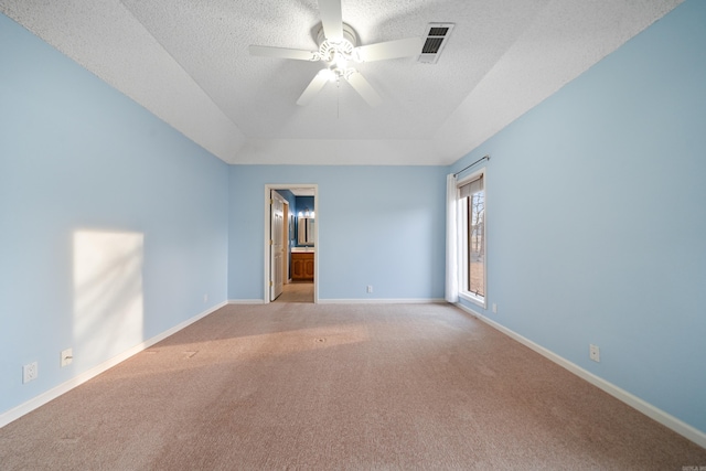 carpeted spare room featuring baseboards, visible vents, a raised ceiling, ceiling fan, and a textured ceiling