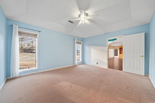 unfurnished bedroom featuring baseboards, multiple windows, visible vents, and carpet flooring