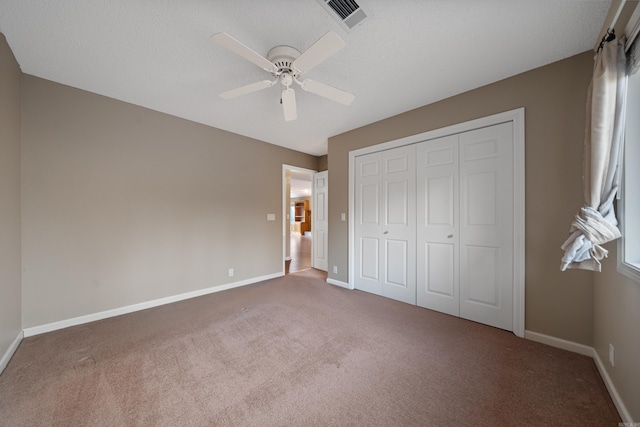 unfurnished bedroom featuring visible vents, baseboards, a ceiling fan, carpet, and a closet