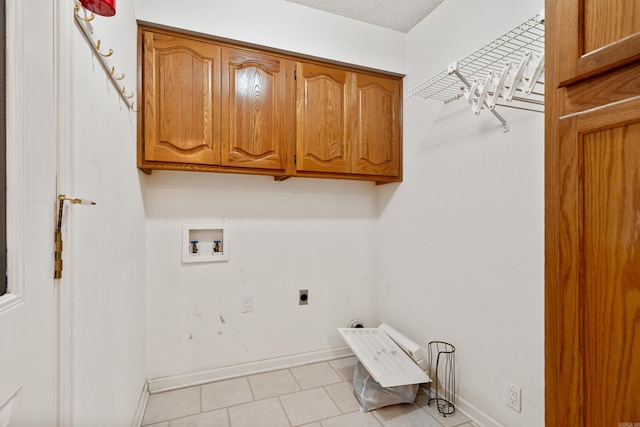 laundry area with hookup for a washing machine, cabinet space, hookup for an electric dryer, a textured ceiling, and baseboards