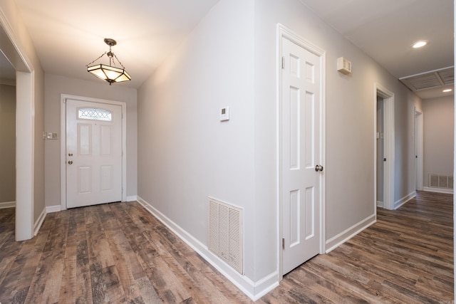 foyer featuring visible vents, dark wood finished floors, and baseboards