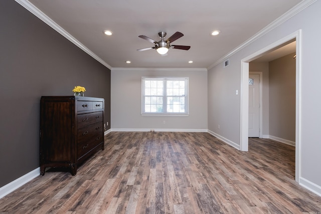 bedroom featuring visible vents, crown molding, baseboards, and wood finished floors