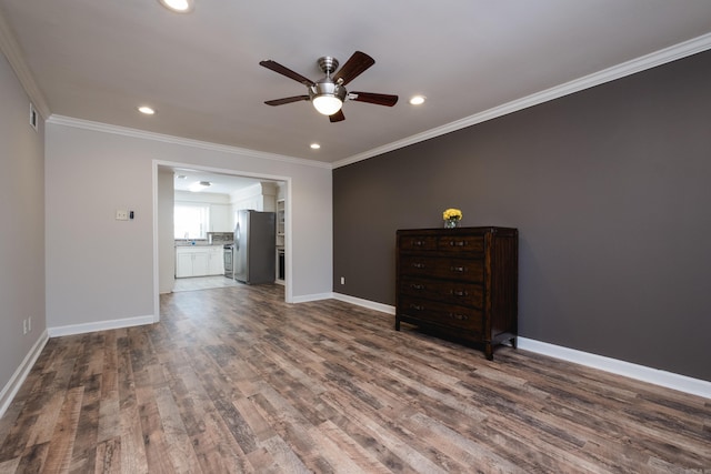 spare room featuring baseboards, dark wood finished floors, and crown molding