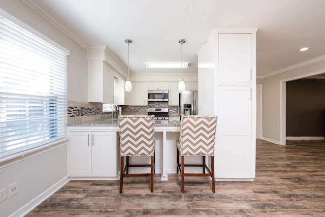 kitchen featuring stainless steel appliances, a peninsula, ornamental molding, tasteful backsplash, and pendant lighting