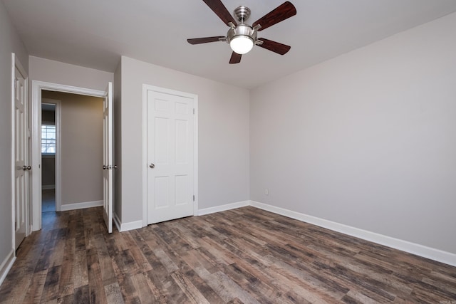 unfurnished bedroom with ceiling fan, wood finished floors, and baseboards