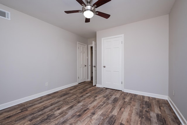 unfurnished bedroom with a ceiling fan, visible vents, baseboards, and wood finished floors