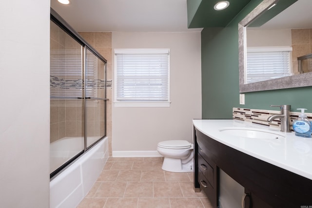 bathroom with baseboards, toilet, enclosed tub / shower combo, vanity, and backsplash