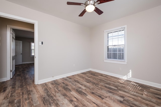 empty room with dark wood-type flooring, plenty of natural light, baseboards, and ceiling fan