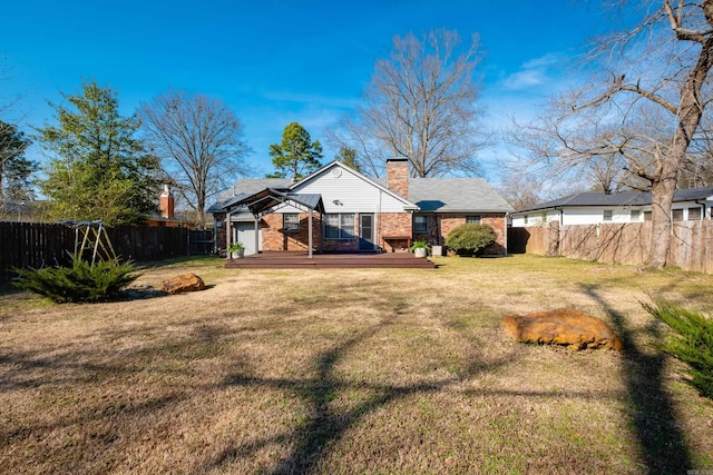 rear view of house featuring a fenced backyard, a wooden deck, a lawn, and brick siding