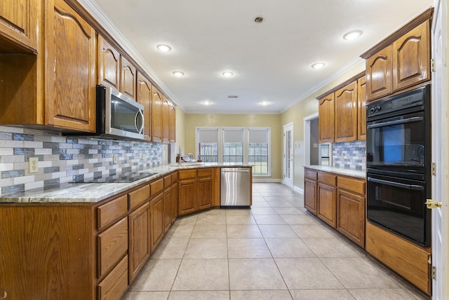 kitchen featuring brown cabinets, light tile patterned floors, ornamental molding, a peninsula, and black appliances