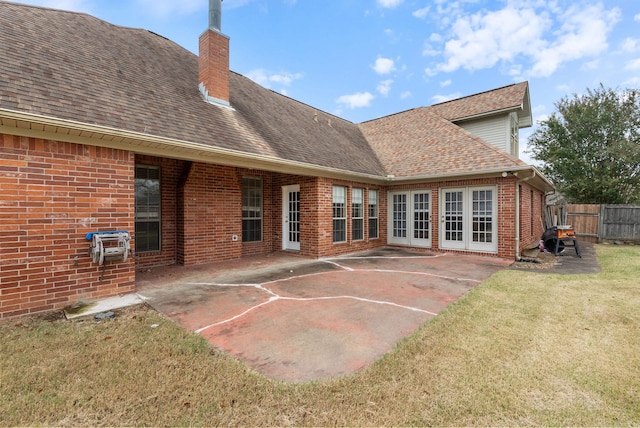 back of house with roof with shingles, a chimney, fence, and brick siding