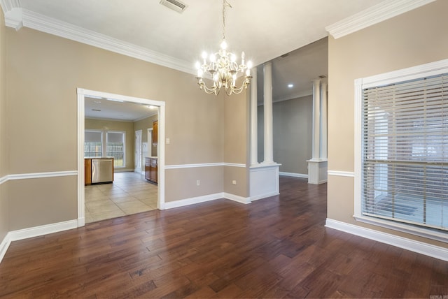 unfurnished dining area featuring ornate columns, visible vents, ornamental molding, wood finished floors, and baseboards