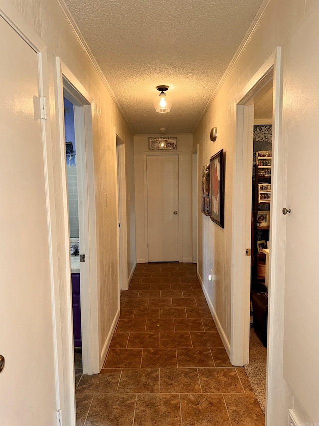 hallway featuring crown molding and a textured ceiling