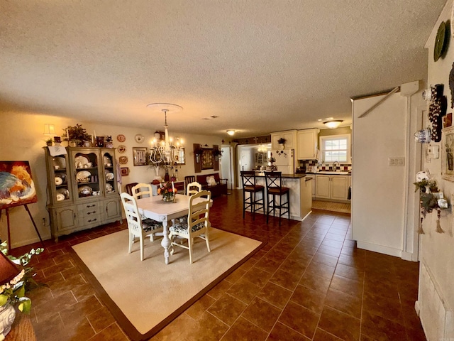 dining space with a textured ceiling and a notable chandelier