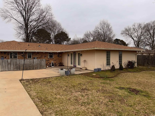 back of property with a yard, a patio area, and fence