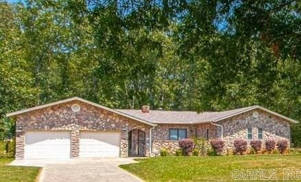 single story home featuring a garage, driveway, and a front yard