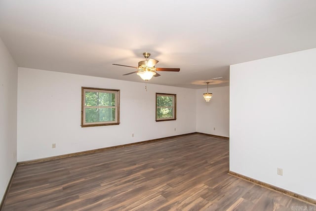 unfurnished room with a ceiling fan, baseboards, and wood finished floors