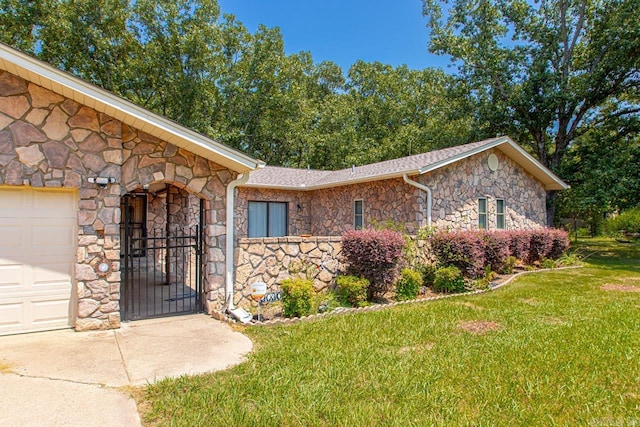 view of front facade with stone siding, an attached garage, and a front yard