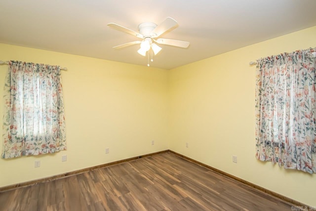 unfurnished room featuring a ceiling fan, baseboards, and dark wood-style flooring