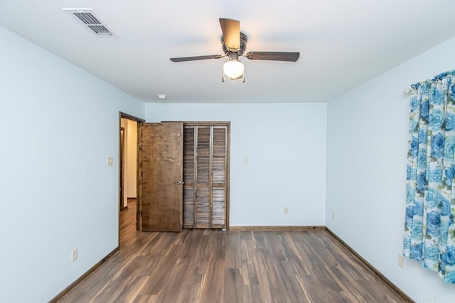 unfurnished room featuring baseboards, ceiling fan, visible vents, and wood finished floors