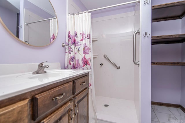 bathroom with marble finish floor, curtained shower, vanity, and baseboards