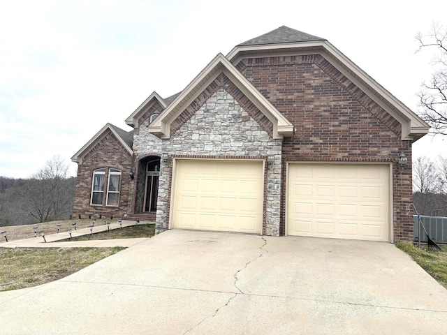 view of front of home featuring a garage, driveway, brick siding, and a shingled roof