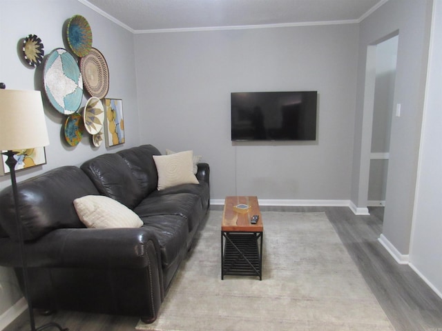 living area featuring crown molding, baseboards, and wood finished floors