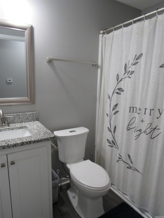 bathroom with vanity, a shower with shower curtain, wood finished floors, and toilet