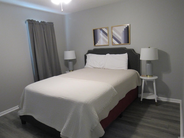 bedroom with baseboards and wood finished floors