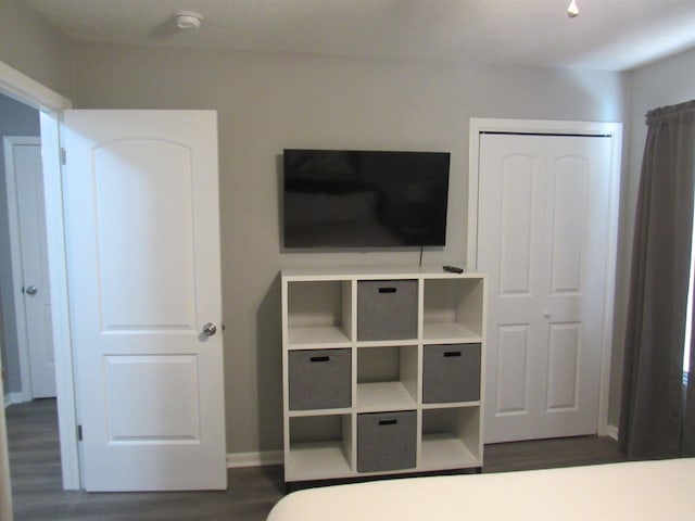 unfurnished bedroom featuring dark wood-type flooring and baseboards