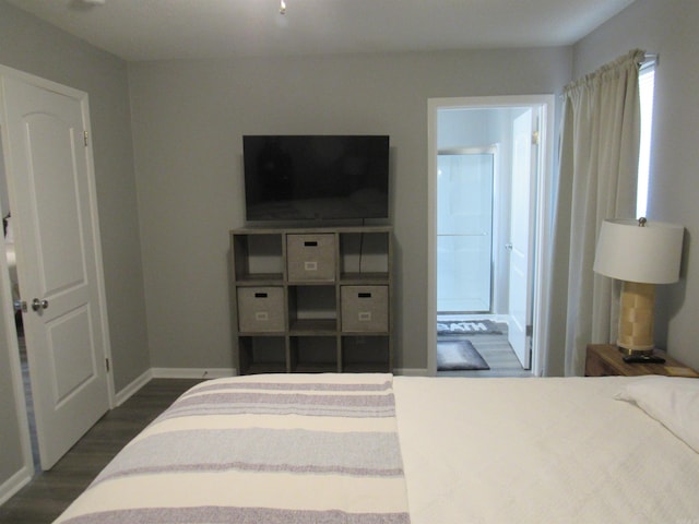 bedroom featuring dark wood-style floors, baseboards, and ensuite bathroom