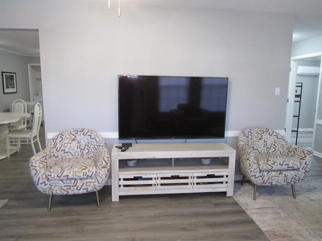 living area featuring a wall mounted air conditioner, wood finished floors, and baseboards