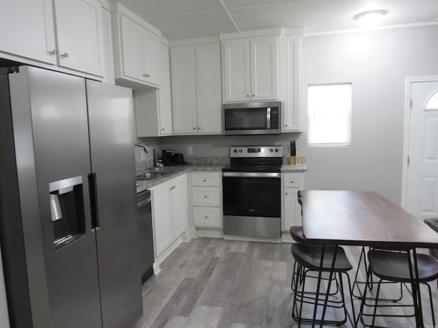 kitchen with white cabinets, stainless steel appliances, and a sink