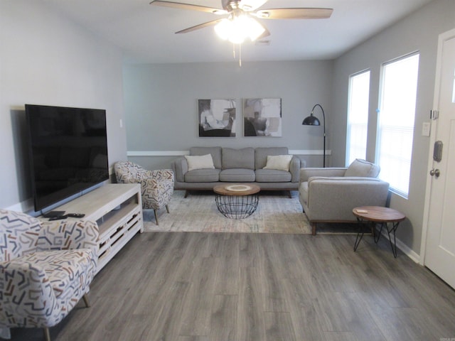 living area featuring a ceiling fan, baseboards, and wood finished floors