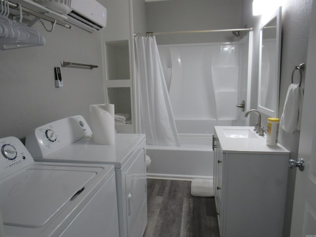 laundry room featuring laundry area, dark wood-style flooring, washing machine and dryer, a sink, and a wall mounted AC