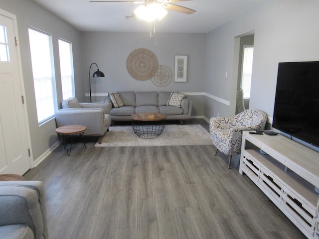 living area with ceiling fan, baseboards, and wood finished floors