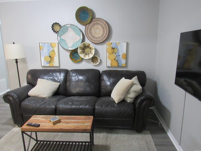 living area with baseboards and wood finished floors