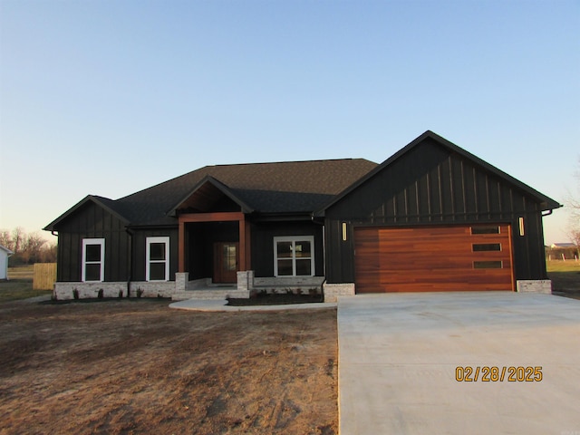 view of front of property with board and batten siding, concrete driveway, and an attached garage