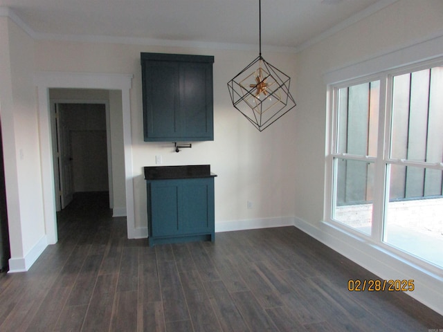 unfurnished dining area with ornamental molding, dark wood finished floors, and baseboards