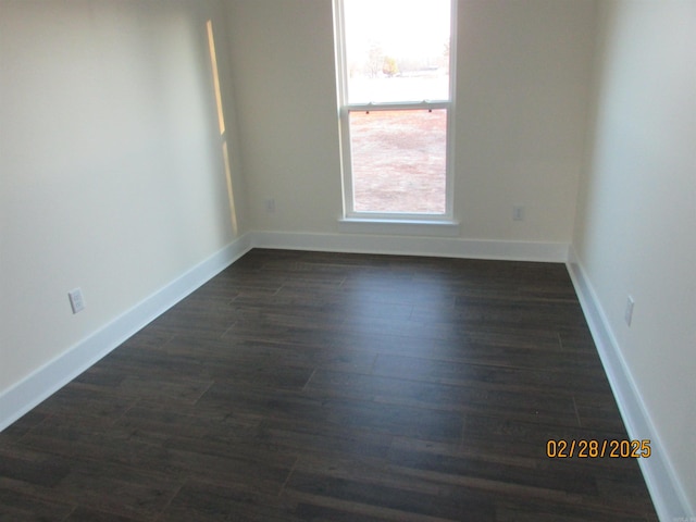 unfurnished room with baseboards and dark wood-style flooring