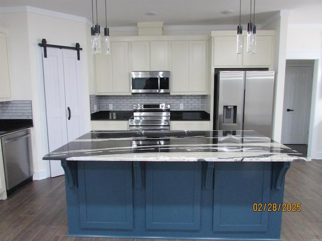 kitchen featuring a barn door, dark wood-style flooring, white cabinets, hanging light fixtures, and appliances with stainless steel finishes