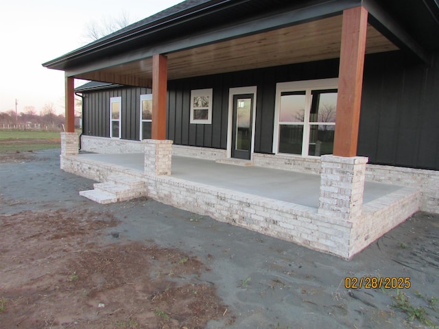 exterior space with board and batten siding and a patio area