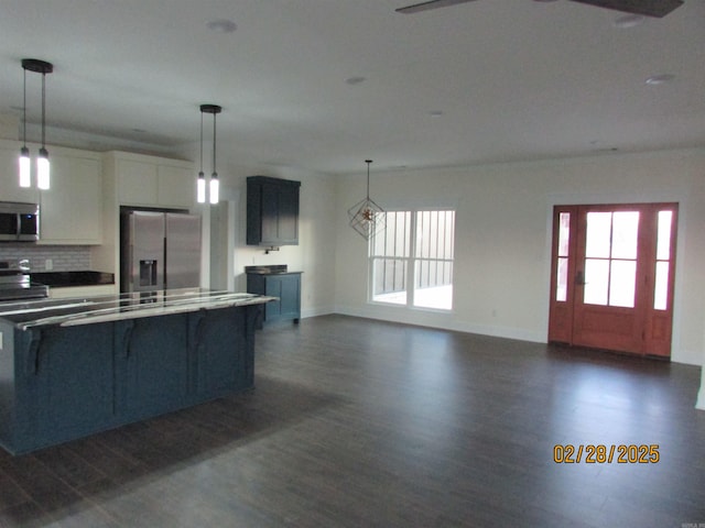 kitchen featuring appliances with stainless steel finishes, a healthy amount of sunlight, white cabinetry, and hanging light fixtures