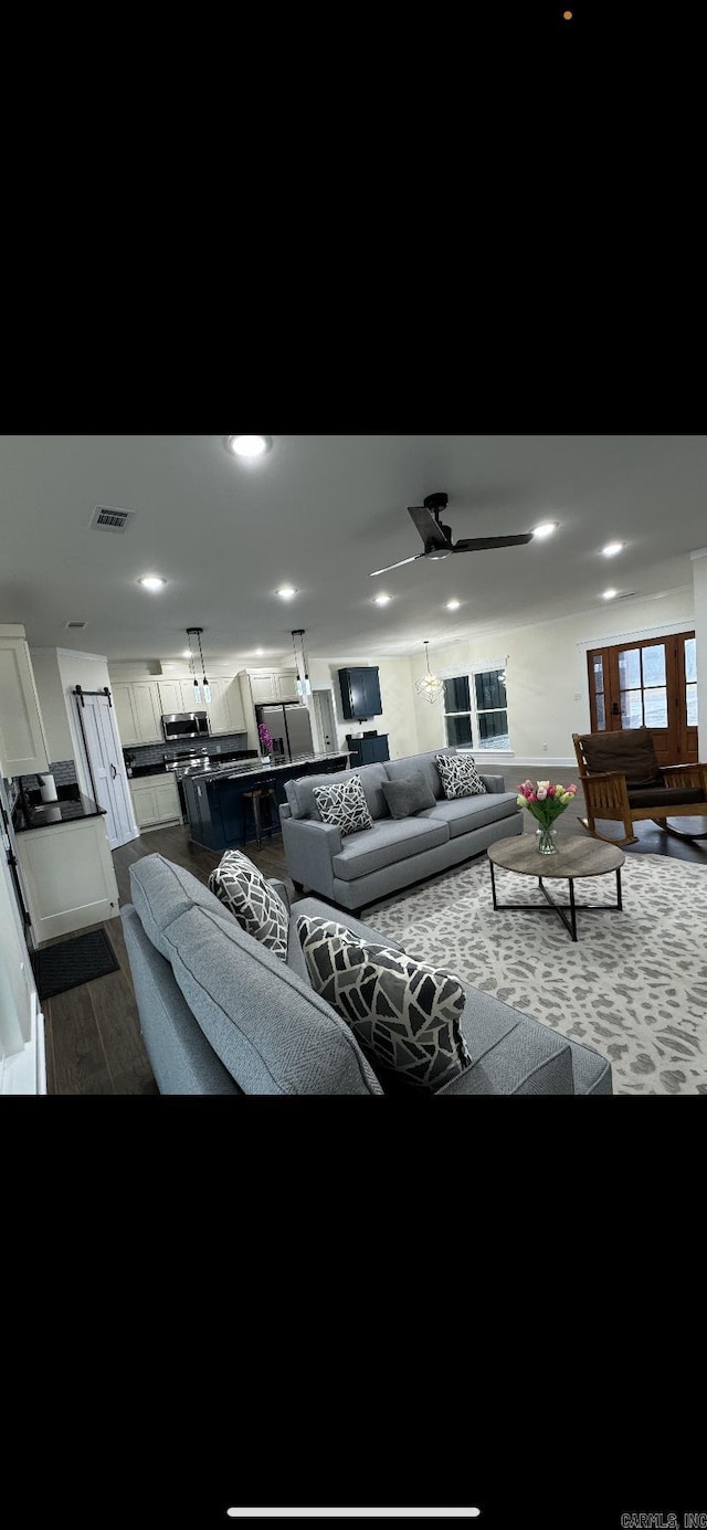 living room featuring ceiling fan, dark wood finished floors, and visible vents