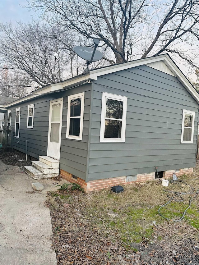 view of side of property featuring crawl space and entry steps