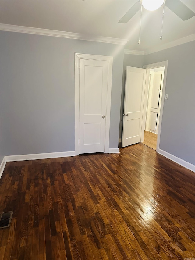 unfurnished room with dark wood-style flooring, visible vents, ornamental molding, a ceiling fan, and baseboards