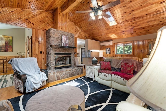 living area with wood finished floors, wooden walls, a wall mounted air conditioner, and ceiling fan
