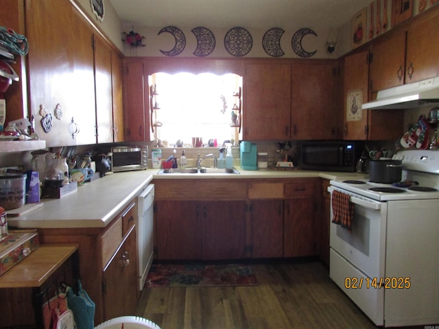 kitchen with light countertops, a sink, wood finished floors, white appliances, and under cabinet range hood